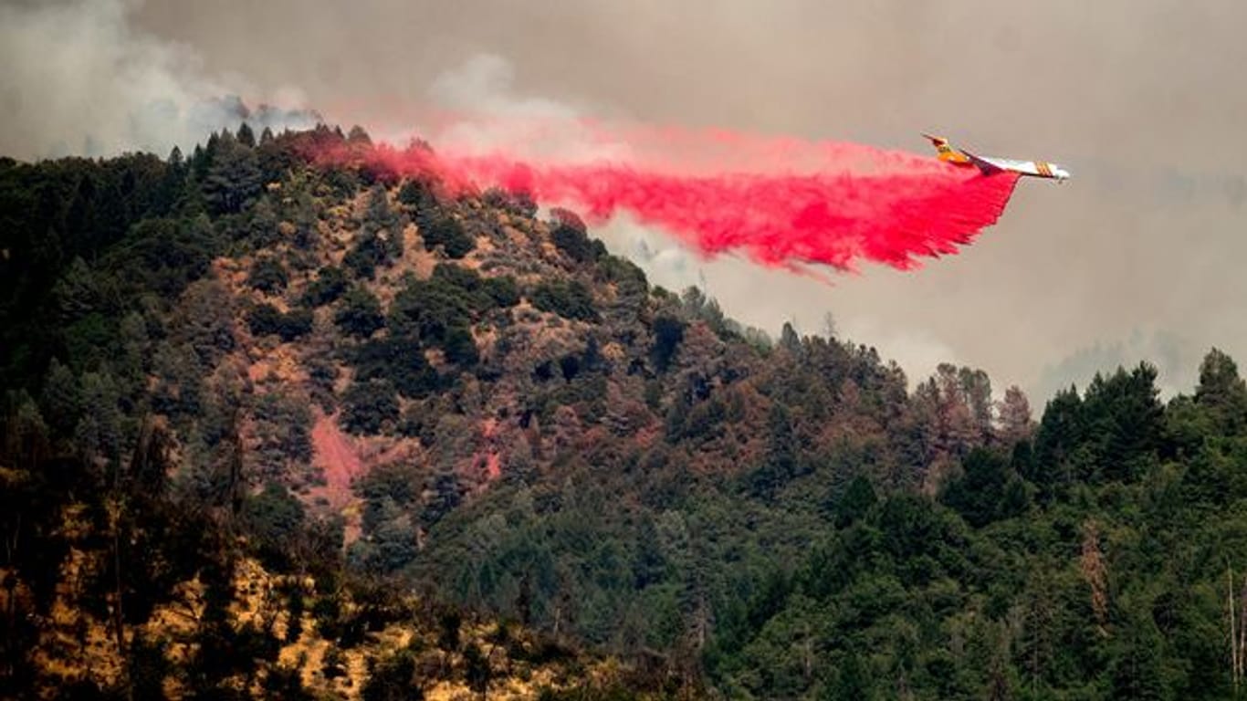 Ein Flugzeug wirft Löschmittel ab, während es versucht, die Ausbreitung des Salt Fire in der Nähe von Lakehead in Kalifornien zu stoppen.