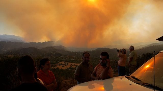 Anwohner beobachten den Waldbrand in der Bergregion von Larnaka auf Zypern. Anwohner beobachten den Waldbrand in der Bergregion von Larnaka auf Zypern.