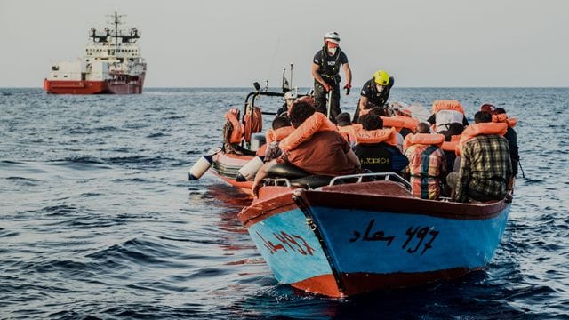 Helfer von der "Ocean Viking" nähern sich einem kleinen Boot.
