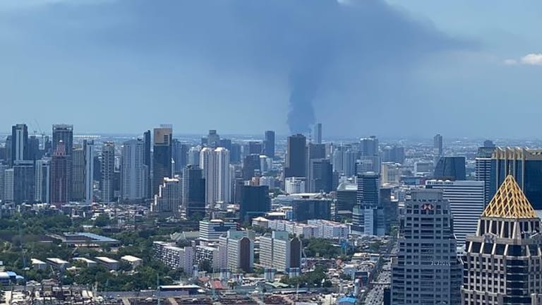 Rauch hinter der Skyline von Bangkok auf.