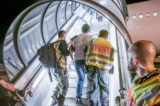 Das Archivfoto aus dem Jahr 2019 zeigt Polizeibeamte, die einen Afghanen bei einer Abschiebung auf dem Flughafen Leipzig-Halle in ein Charterflugzeug begleiten.