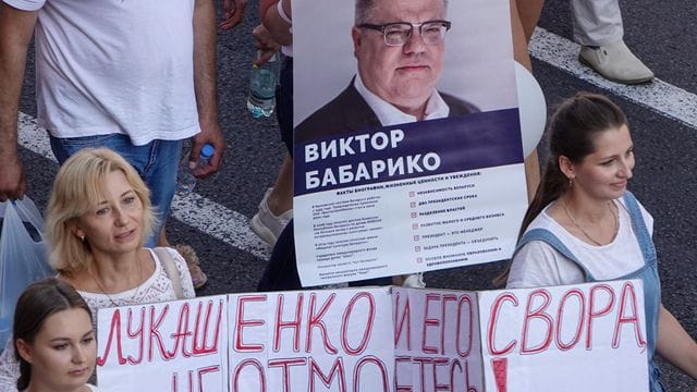 Menschen bei einer Demonstration gegen Machthaber Lukschenko mit einerm Transparent das den Oppositionellen Viktor Babariko zeigt. Menschen bei einer Demonstration gegen Machthaber Lukschenko mit einerm Transparent das den Oppositionellen Viktor Babariko zeigt.