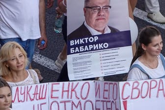 Menschen bei einer Demonstration gegen Machthaber Lukschenko mit einerm Transparent das den Oppositionellen Viktor Babariko zeigt.