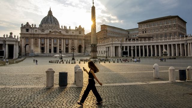 Eine Frau spaziert auf dem Petersplatz. Eine Frau spaziert auf dem Petersplatz.