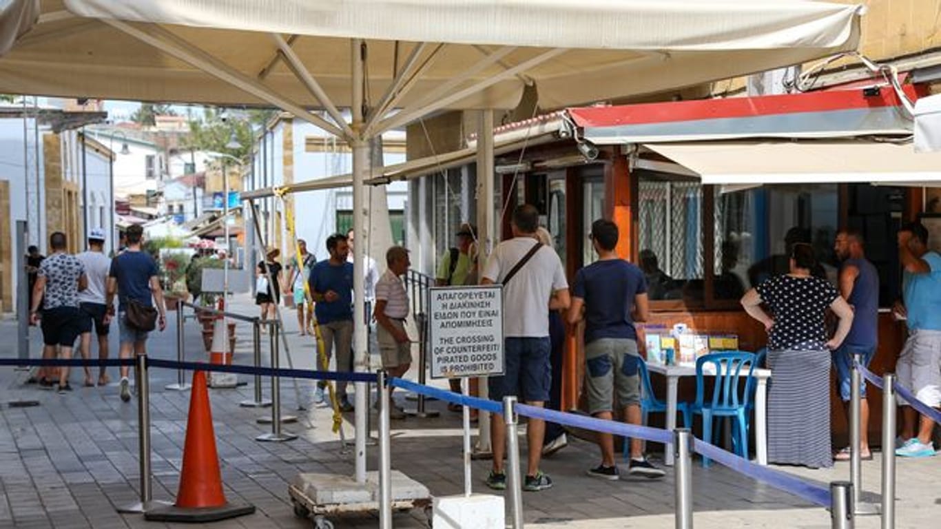 Menschen stehen in Zyperns Hauptstadt Nikosia am Grenzübergang zum türkischen Teil der Stadt.
