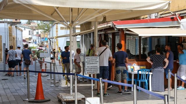Menschen stehen in Zyperns Hauptstadt Nikosia am Grenzübergang zum türkischen Teil der Stadt. Menschen stehen in Zyperns Hauptstadt Nikosia am Grenzübergang zum türkischen Teil der Stadt.