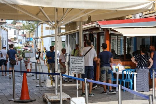 Menschen stehen in Zyperns Hauptstadt Nikosia am Grenzübergang zum türkischen Teil der Stadt.