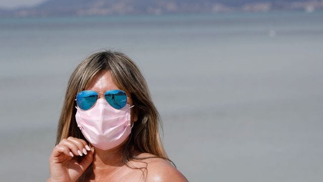 Maske am Strand: Auch 2021 steht der Sommerurlaub - wie hier auf Mallorca - ganz im Zeichen der Pandemie. Maske am Strand: Auch 2021 steht der Sommerurlaub - wie hier auf Mallorca - ganz im Zeichen der Pandemie.