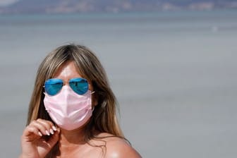 Maske am Strand: Auch 2021 steht der Sommerurlaub - wie hier auf Mallorca - ganz im Zeichen der Pandemie.