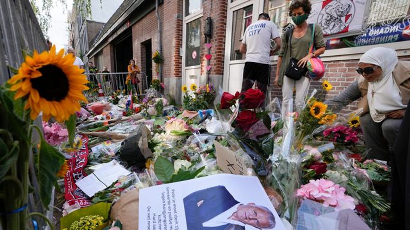 Menschen haben Bilder des Kriminalreporters und Blumen am Tatort niedergelegt.