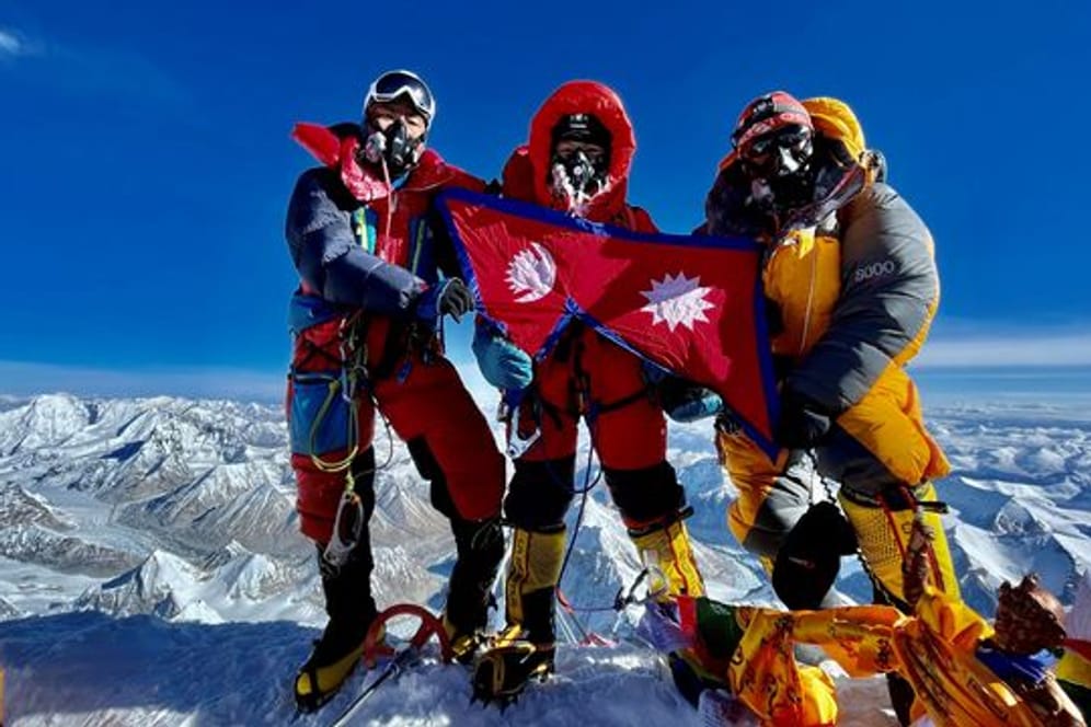 Nima Lhamu Sherpa (M) steht mit ihren Brüdern auf dem Gipfel des Mount Everest.