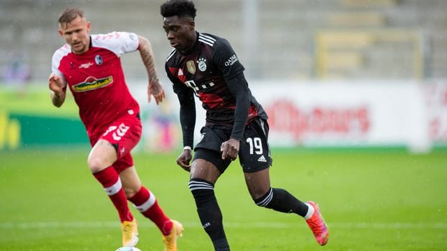 Bayerns Alphonso Davies (r) im Laufduell mit Freiburgs Jonathan Schmid. Bayerns Alphonso Davies (r) im Laufduell mit Freiburgs Jonathan Schmid.