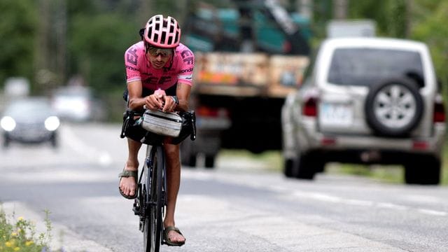 Mit Sandalen und Gepäck: Lachlan Morton fuhr die Tour de France vor seinen Teamkollegen und dem Feld ab.