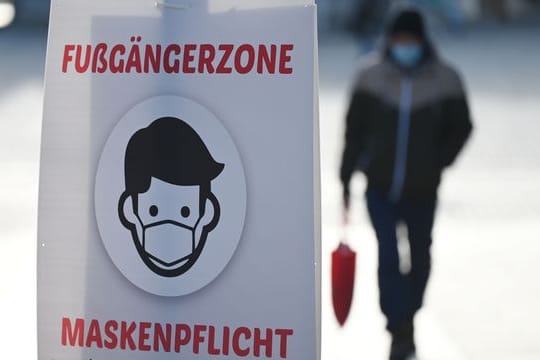 Ein Schild weist auf die Maskenpflicht in der Fußgängerzone hin.