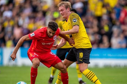 Gießens Nejmeddin Daghfous (l) und Dortmunds Julian Brandt kämpfen um den Ball.