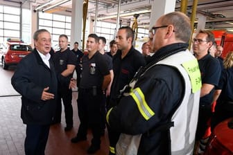 Der nordrhein-westfälische Ministerpräsident Armin Laschet (CDU, l) bedankt sich bei Hagenern Feuerwehrleuten für ihren Einsatz.