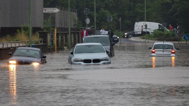 Mehrere Autos stecken nach Starkregen auf einer überfluteten Straße in Stolberg in NRW fest. Mehrere Autos stecken nach Starkregen auf einer überfluteten Straße in Stolberg in NRW fest.