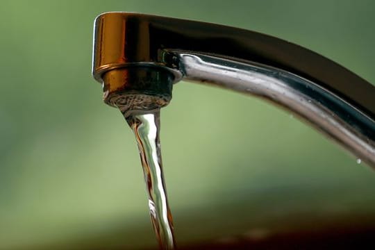 Leitungswasser fließt aus einem Wasserhahn.