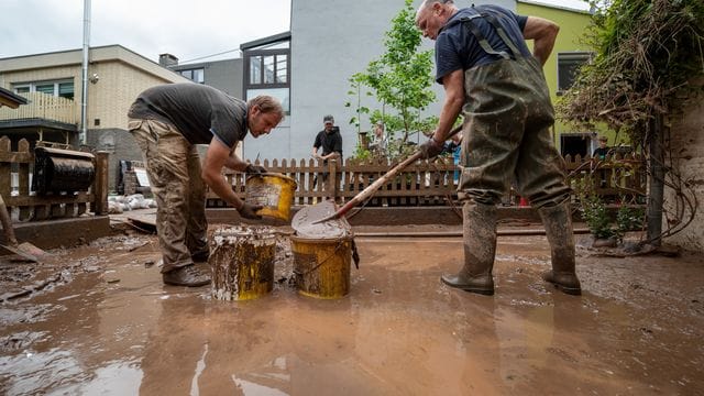 Mit Eimern entsorgen Anwohner die Schlammmassen nach dem Hochwasser der Kyll. Mit Eimern entsorgen Anwohner die Schlammmassen nach dem Hochwasser der Kyll.