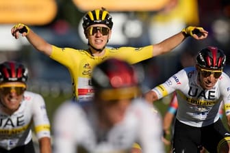 Geschafft: Tadej Pogacar feiert im Gelben Trikot nach der Zieleinfahrt in Paris seinen zweiten Gesamtsieg bei der Tour de France.