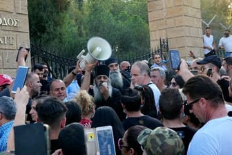 Ein griechisch-orthodoxer Priester spricht zu Demonstranten während des Protests gegen die Corona-Maßnahmen vor dem Präsidentenpalast.