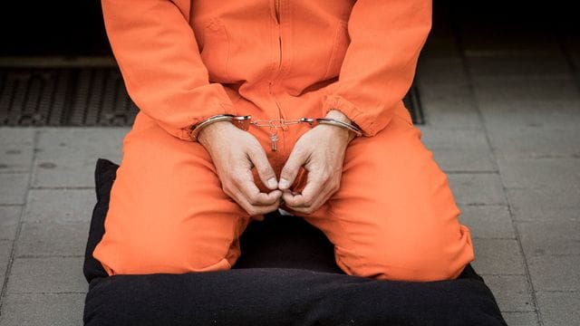 Ein Mann in Gefängniskleidung. Ein Mann in Gefängniskleidung.