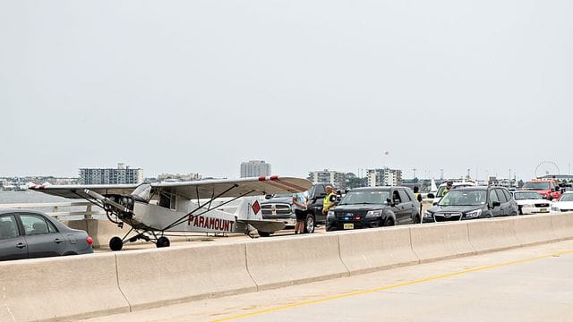 Rettungskräfte im Gespräch mit dem Piloten, der notgelandet ist. Rettungskräfte im Gespräch mit dem Piloten, der notgelandet ist.