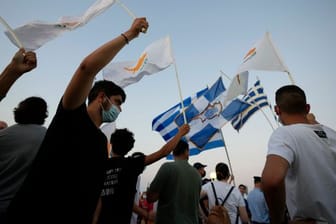 Bewohner der verlassenen Stadt Varosha oder Famagusta halten zypriotische und griechische Fahnen während eines Protestes gegen den türkischen Präsidenten Erdogan.