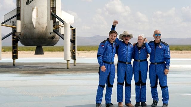 Oliver Daemen (l-r) aus den Niederlanden, Jeff Bezos, Gründer von Amazon und des Weltraumtourismus-Unternehmens Blue Origin, Wally Funk, ehemalige US-Pilotin, und Mark Bezos, Bruder von Jeff Bezos, stehen nach der Landung für ein Foto zusammen.