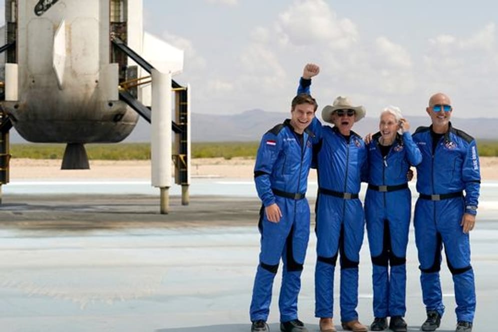 Oliver Daemen (l-r) aus den Niederlanden, Jeff Bezos, Gründer von Amazon und des Weltraumtourismus-Unternehmens Blue Origin, Wally Funk, ehemalige US-Pilotin, und Mark Bezos, Bruder von Jeff Bezos, stehen nach der Landung für ein Foto zusammen.