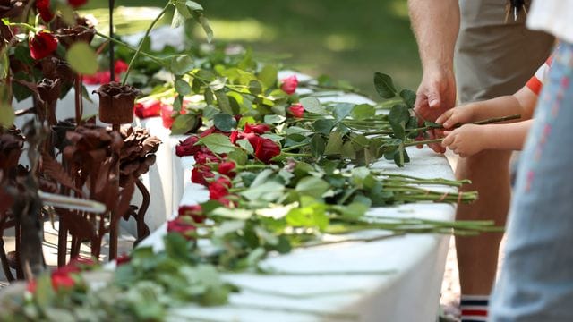 Menschen legen in Oslo Rosen für die Opfer des Terroranschlags nieder.