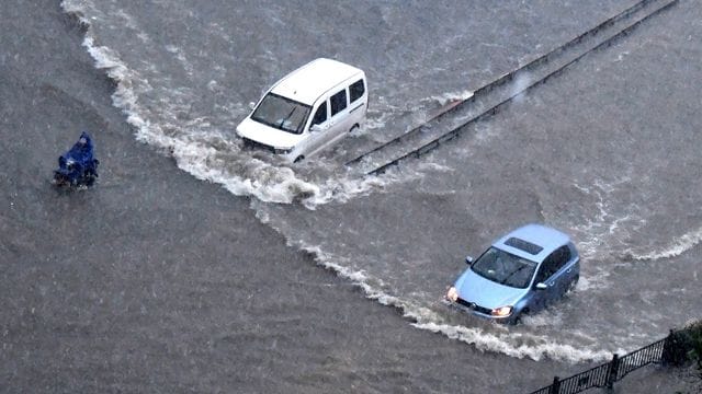 Fahrzeuge bahnen sich ihren Weg durch die Fluten in Zhengzhou in der zentralchinesischen Provinz Henan. Fahrzeuge bahnen sich ihren Weg durch die Fluten in Zhengzhou in der zentralchinesischen Provinz Henan.