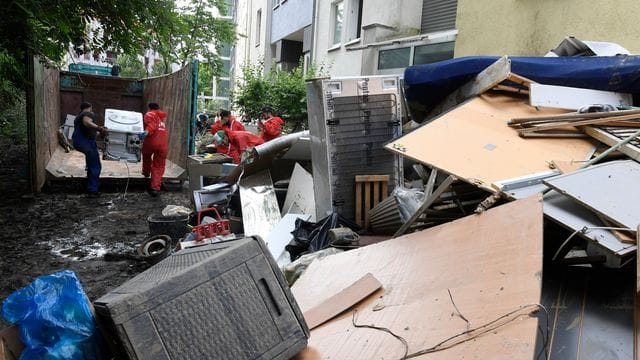 Helfer beseitigen in Opladen in Nordrhein-Westfalen die nach der Flutkatastrophe zurückgebliebenen Müllberge. Helfer beseitigen in Opladen in Nordrhein-Westfalen die nach der Flutkatastrophe zurückgebliebenen Müllberge.