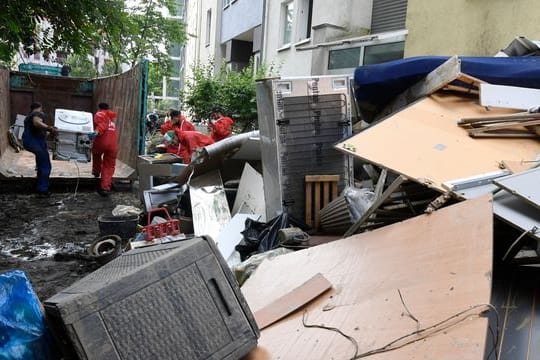 Helfer beseitigen in Opladen in Nordrhein-Westfalen die nach der Flutkatastrophe zurückgebliebenen Müllberge.
