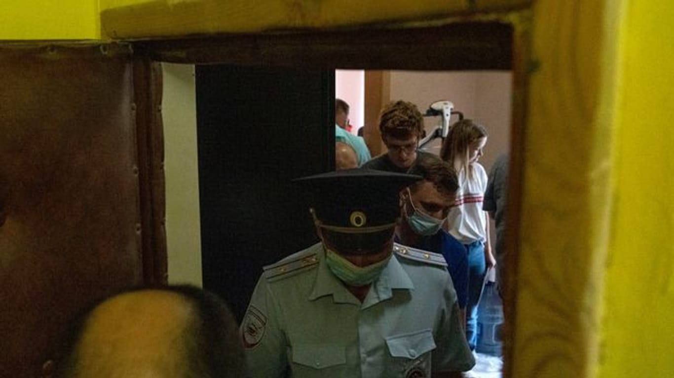 Polizisten verlassen die Wohnung der Journalistin Maria Zholobova in Moskau.