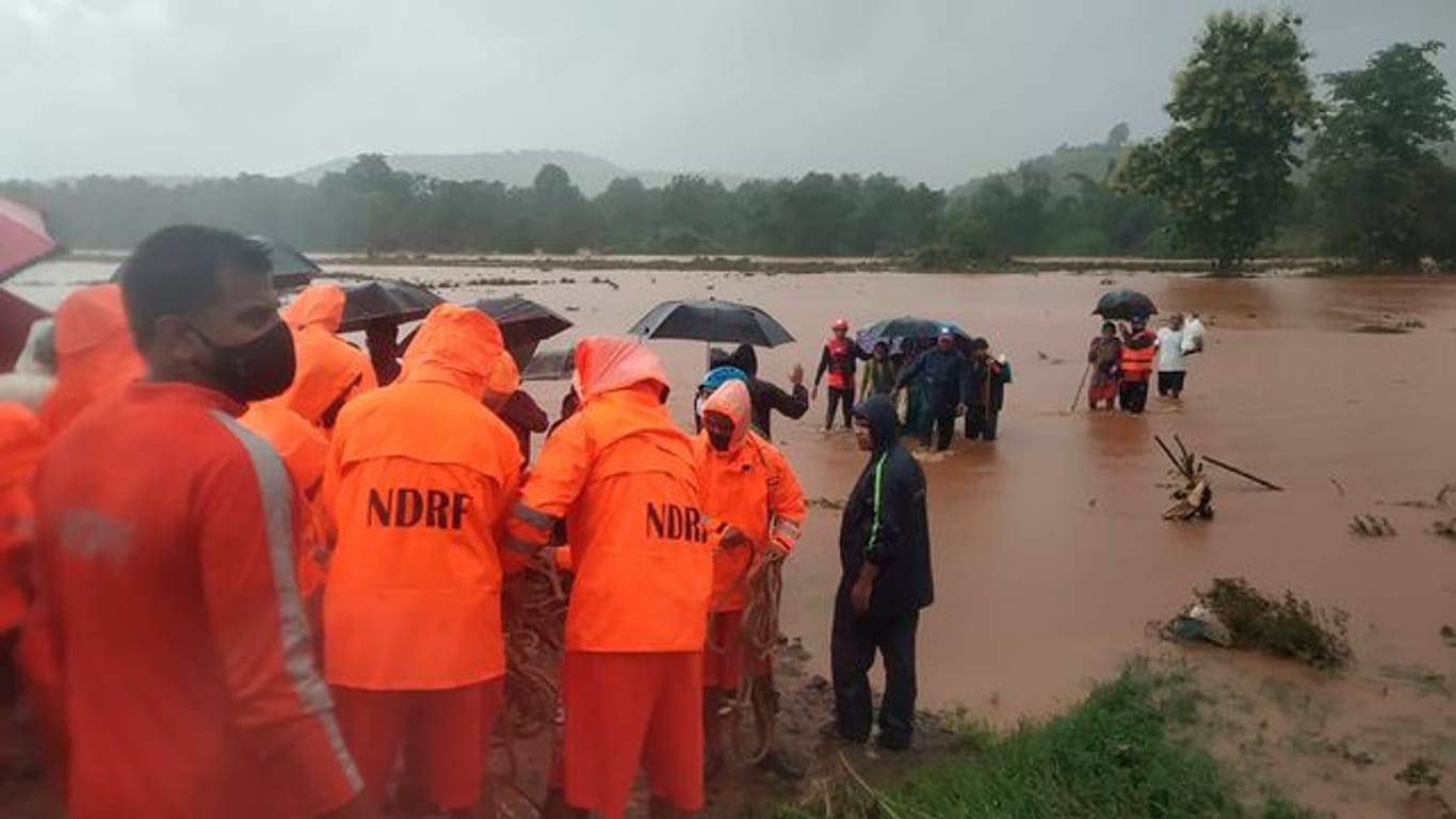 Rettungskräfte des Katastrophenschutzes bei der Evakuierung von Menschen im indischen Chiplun.
