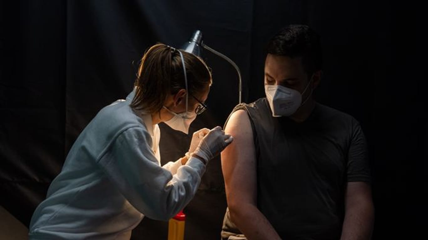 Eine Mitarbeiterin des Arbeiter-Samariter-Bundes (ASB) klebt nach einer Corona-Schutzimpfung ein Pflaster auf.