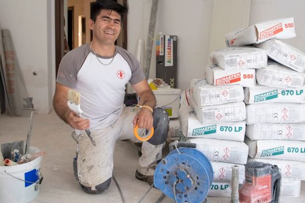 Der aus Afghanistan geflohene Najibullah Alizadah arbeitet auf einer Baustelle auf dem Gelände der Universität.