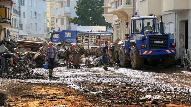 Mitarbeiter des Technischen Hilfswerks (THW) helfen bei Aufräumarbeiten nach der Unwetterkatastrophe in einer verschlammten Straße. Mitarbeiter des Technischen Hilfswerks (THW) helfen bei Aufräumarbeiten nach der Unwetterkatastrophe in einer verschlammten Straße.