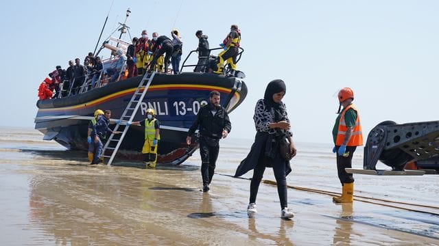 Eine Gruppe von Menschen, bei denen es sich vermutlich um Migranten handelt, geht von Bord des örtlichen Rettungsboots in Kent, nachdem sie nach einem Zwischenfall mit einem kleinen Boot im Ärmelkanal aufgegriffen wurde.