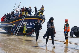 Eine Gruppe von Menschen, bei denen es sich vermutlich um Migranten handelt, geht von Bord des örtlichen Rettungsboots in Kent, nachdem sie nach einem Zwischenfall mit einem kleinen Boot im Ärmelkanal aufgegriffen wurde.