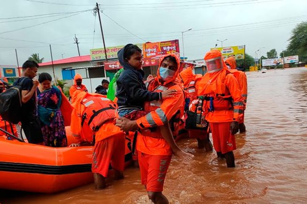 Dieses vom indischen Katastrophenschutz (NDRF) zur Verfügung gestellte Foto zeigt Rettungskräfte des Katastrophenschutzes beim Retten von Bewohnern der Gegend um Chiplun.