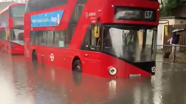 Ein Londoner Bus auf einer überschwemmten Straße.