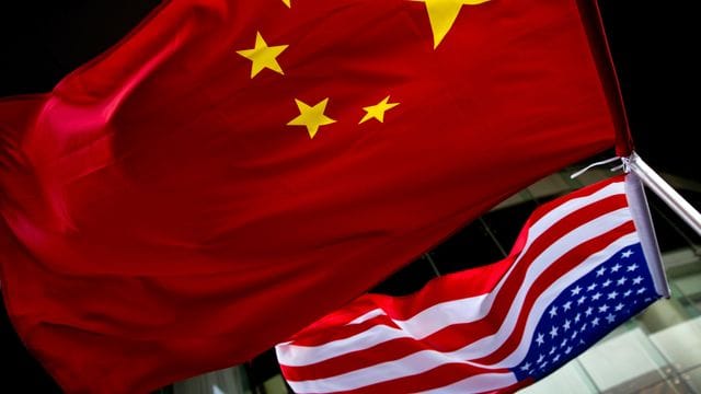 Eine us-amerikanische (unten) und eine chinesische Nationalflagge wehen vor einem Hotel in Peking. Eine us-amerikanische (unten) und eine chinesische Nationalflagge wehen vor einem Hotel in Peking.