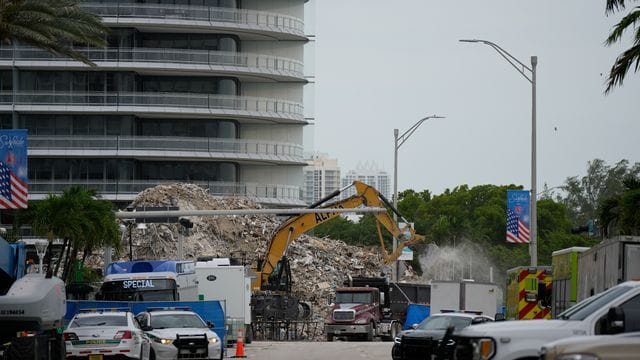 Ein Bagger entfernt Trümmer des eingestürzten Gebäudes im US-Bundesstaat Florida. Ein Bagger entfernt Trümmer des eingestürzten Gebäudes im US-Bundesstaat Florida.