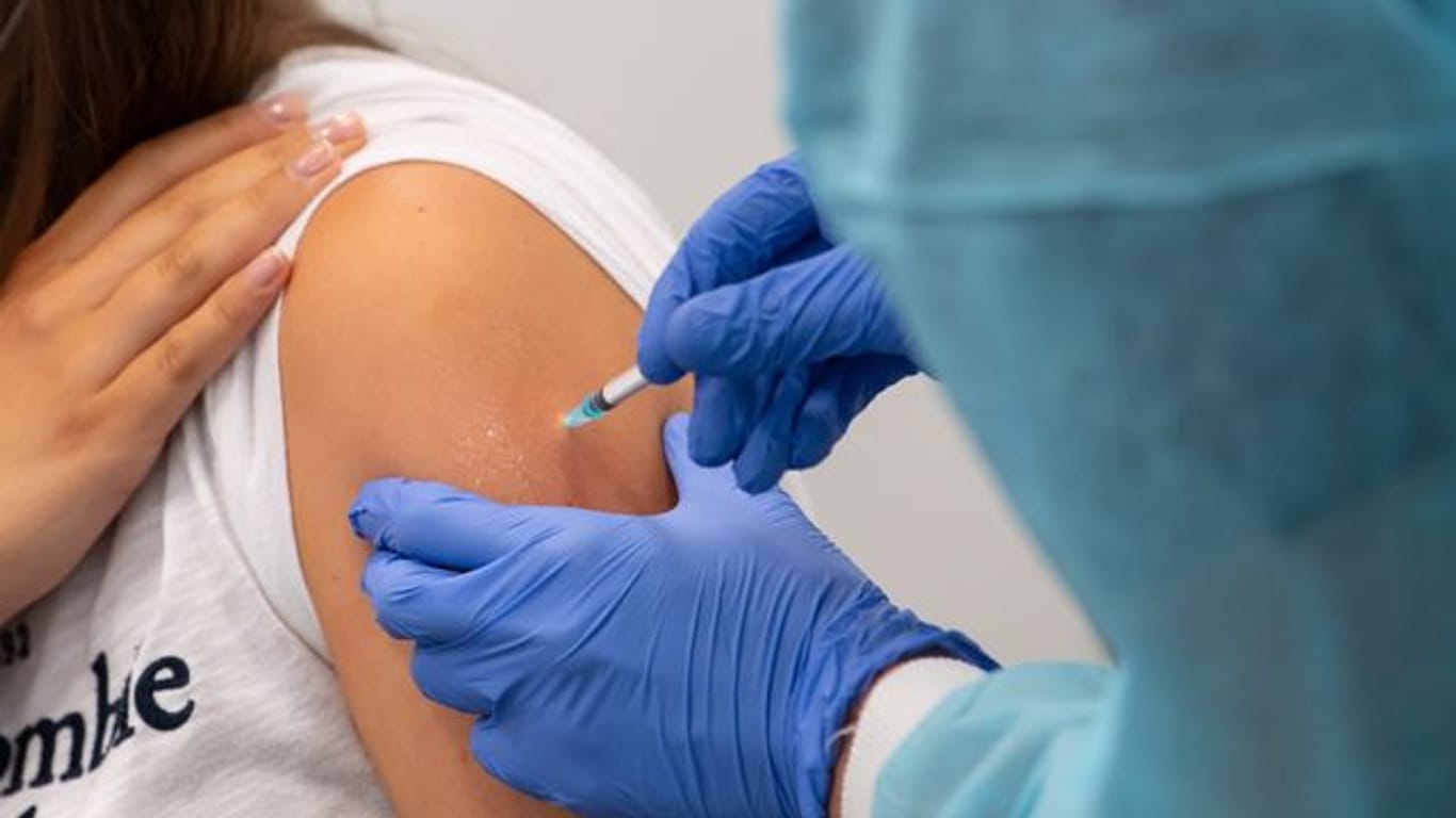 Eine Frau bekommt in einem Impfzentrum eine Corona-Impfung verabreicht.