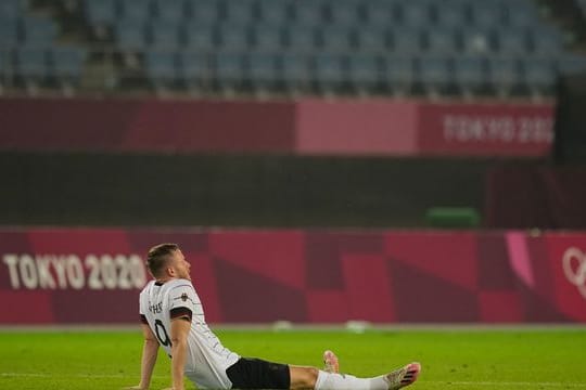 Cedric Teuchert sitzt nach dem Ausscheiden enttäuscht auf dem Rasen.