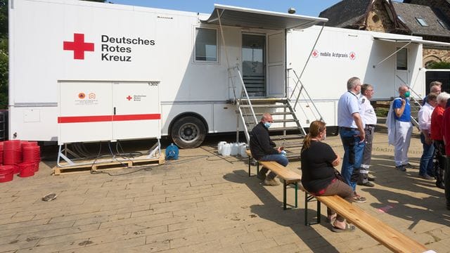 Menschen warten vor einer mobilen Arztpraxis des Deutschen Roten Kreuzes in Bad Neuenahr-Ahrweiler. Menschen warten vor einer mobilen Arztpraxis des Deutschen Roten Kreuzes in Bad Neuenahr-Ahrweiler.