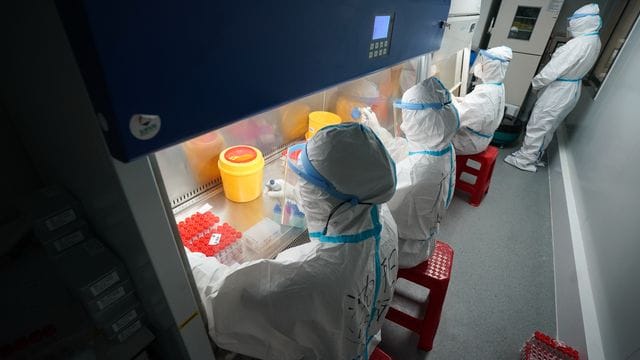 Mitarbeiter arbeiten in einem temporären Labor für Nukleinsäure-Tests im Nanjing-Bahnhof in der Hauptstadt der ostchinesischen Provinz Jiangsu.