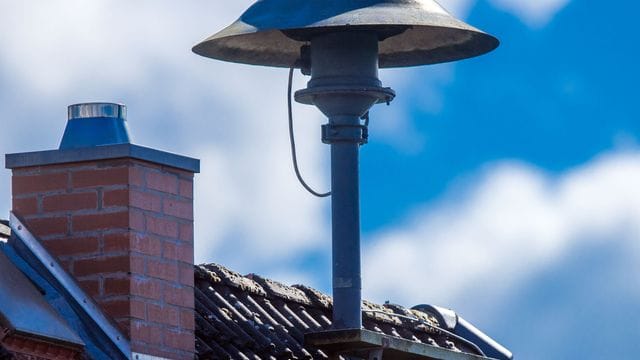 Eine Alarmsirene steht auf einem Hausdach. Eine Alarmsirene steht auf einem Hausdach.